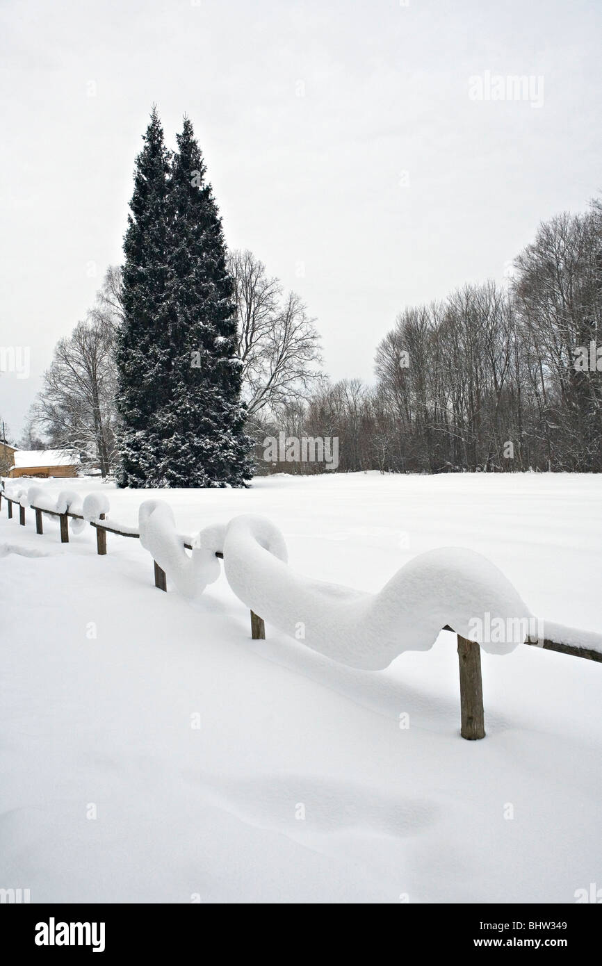 Heaps of snow on wooden fence in Allazu countryside in Vidzeme Latvia Stock Photo