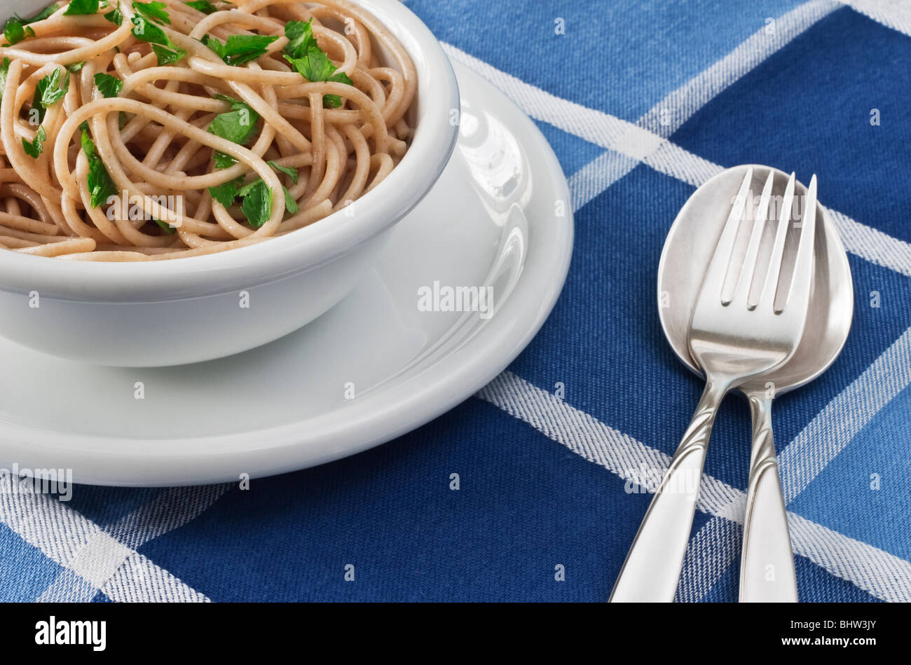 A Bowl of plain Wholewheat Spaghetti garnished with Parsley Stock Photo