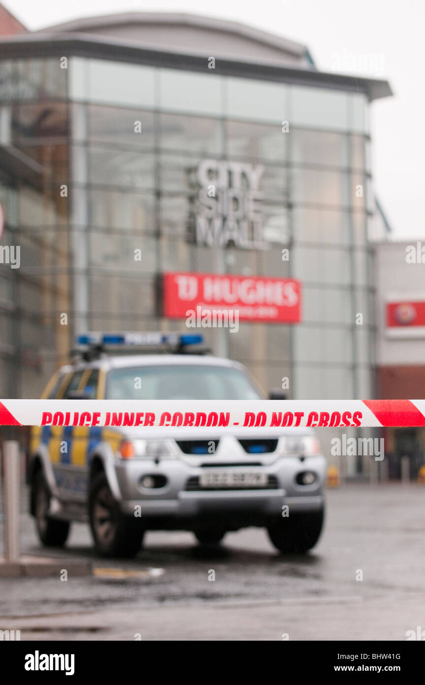 Police car behind cordon tape at a hoax bomb alert, City Side Mall, Belfast in rain Stock Photo