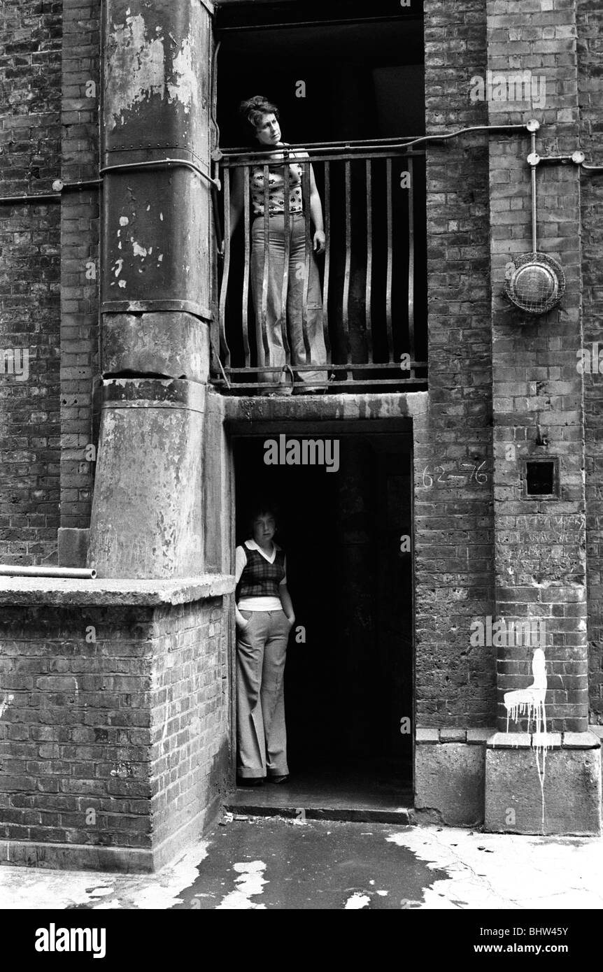 Victorian Slum Buildings Tower Hamlets Whitechapel east London UK 1970s. Peabody social housing estate residents looking out onto the  communal courtyard. 1975 HOMER SYKES. Stock Photo