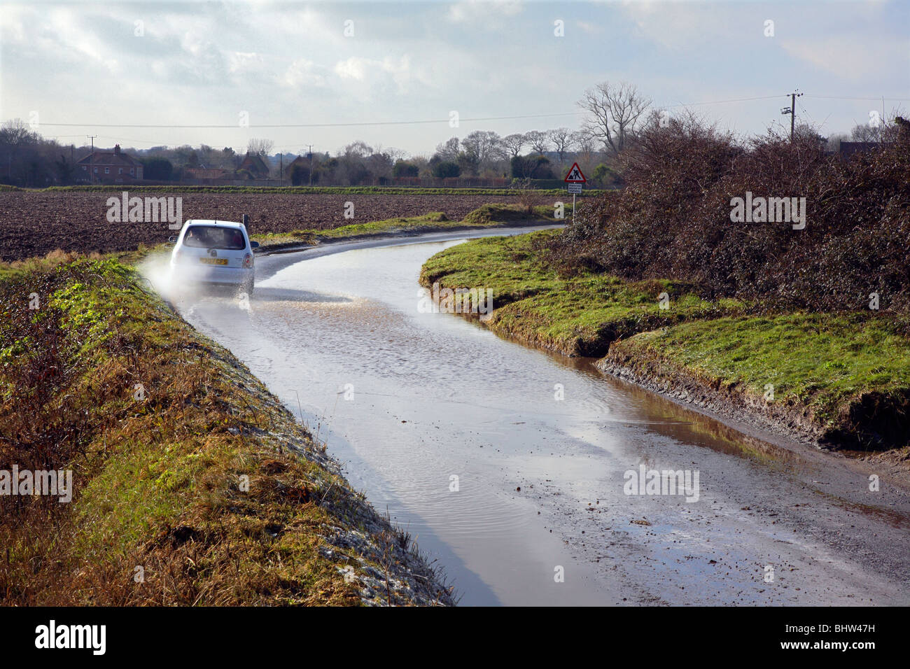 Car driving along flooded country road Stock Photo - Alamy