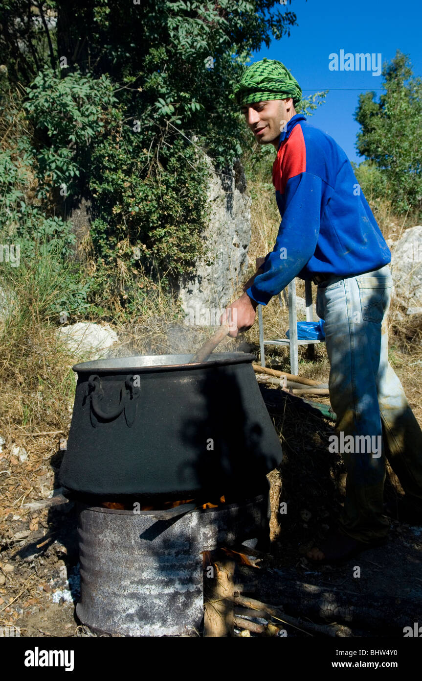 Man making Carob ceratoniasiliqua in Lebanon Middle East Asia Stock Photo