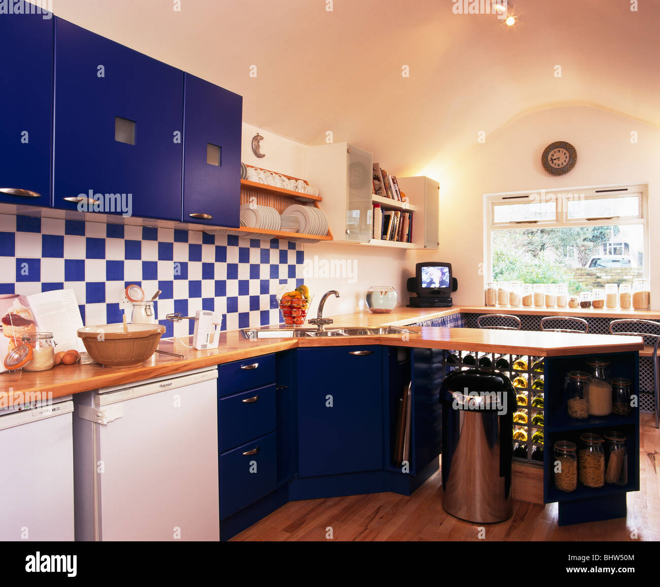 Blue+white wall tiles in modern kitchen with blue fitted cupboards ...