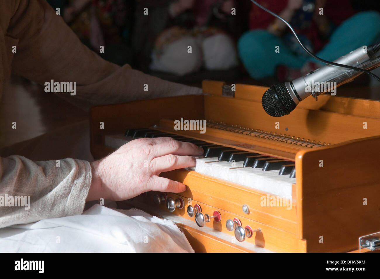 Hare Krishna devotee playing a harmonium at a Sunday afternoon Kirtana (Chanting ceremony) Stock Photo