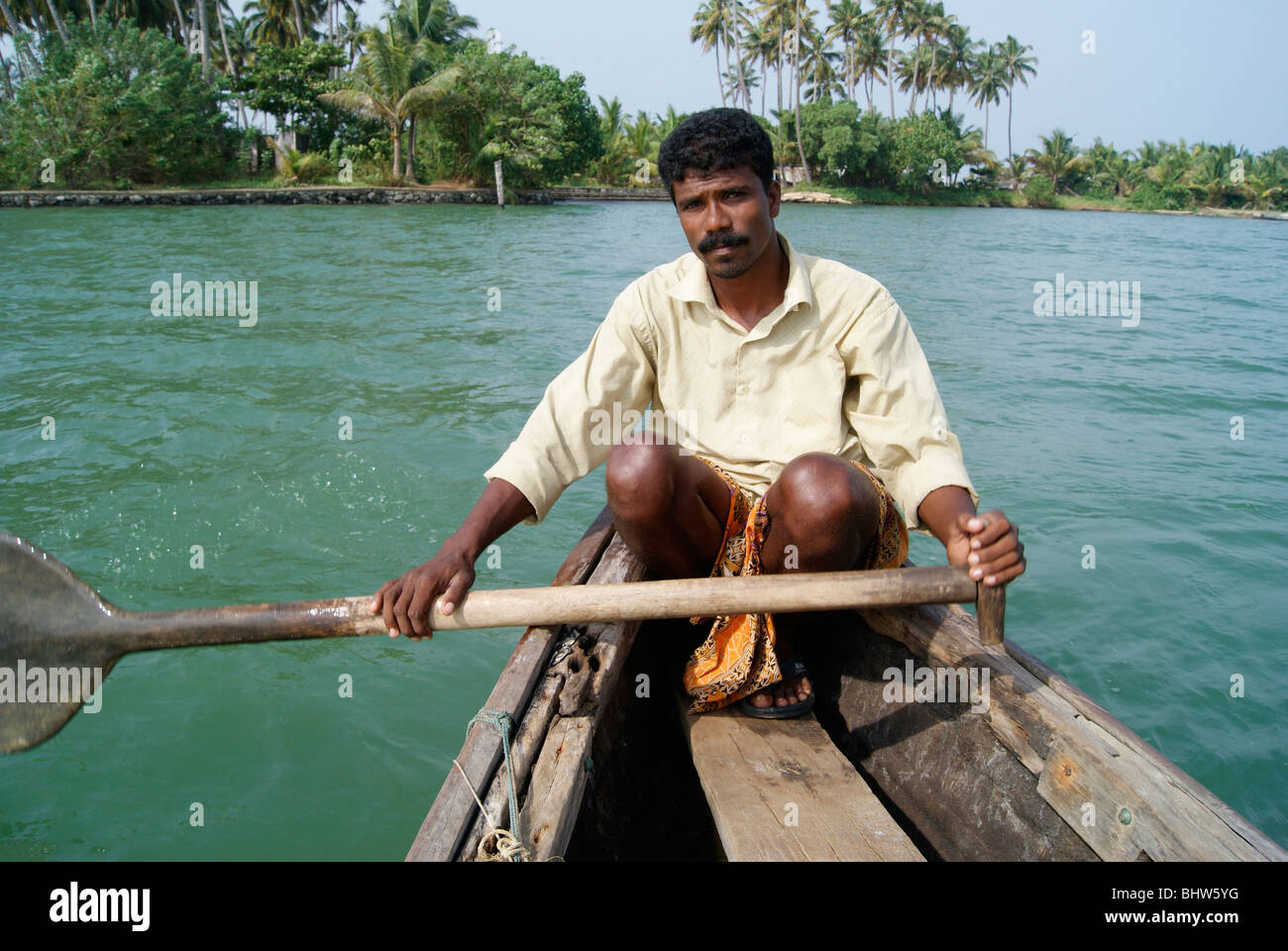 Man rowing (sailing) Wooden Native Village Boat in beautiful kerala