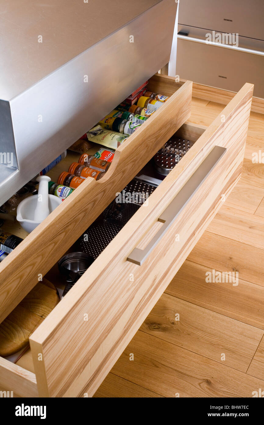 Close Up Of Open Kitchen Storage Drawers With Spice Jars Stock