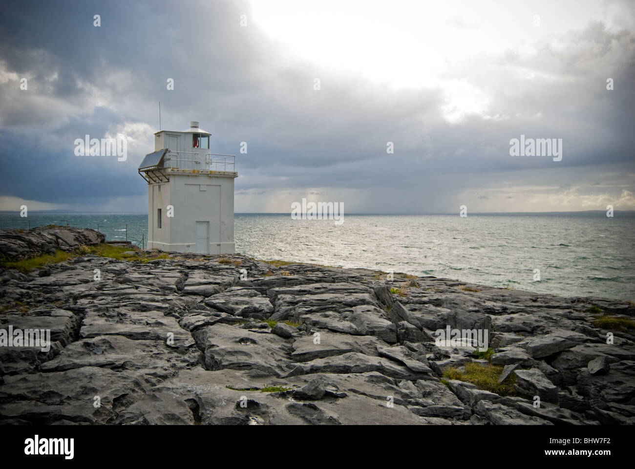 The Black Head lighthouse with distant storms over the Atlantic Ocean. Stock Photo