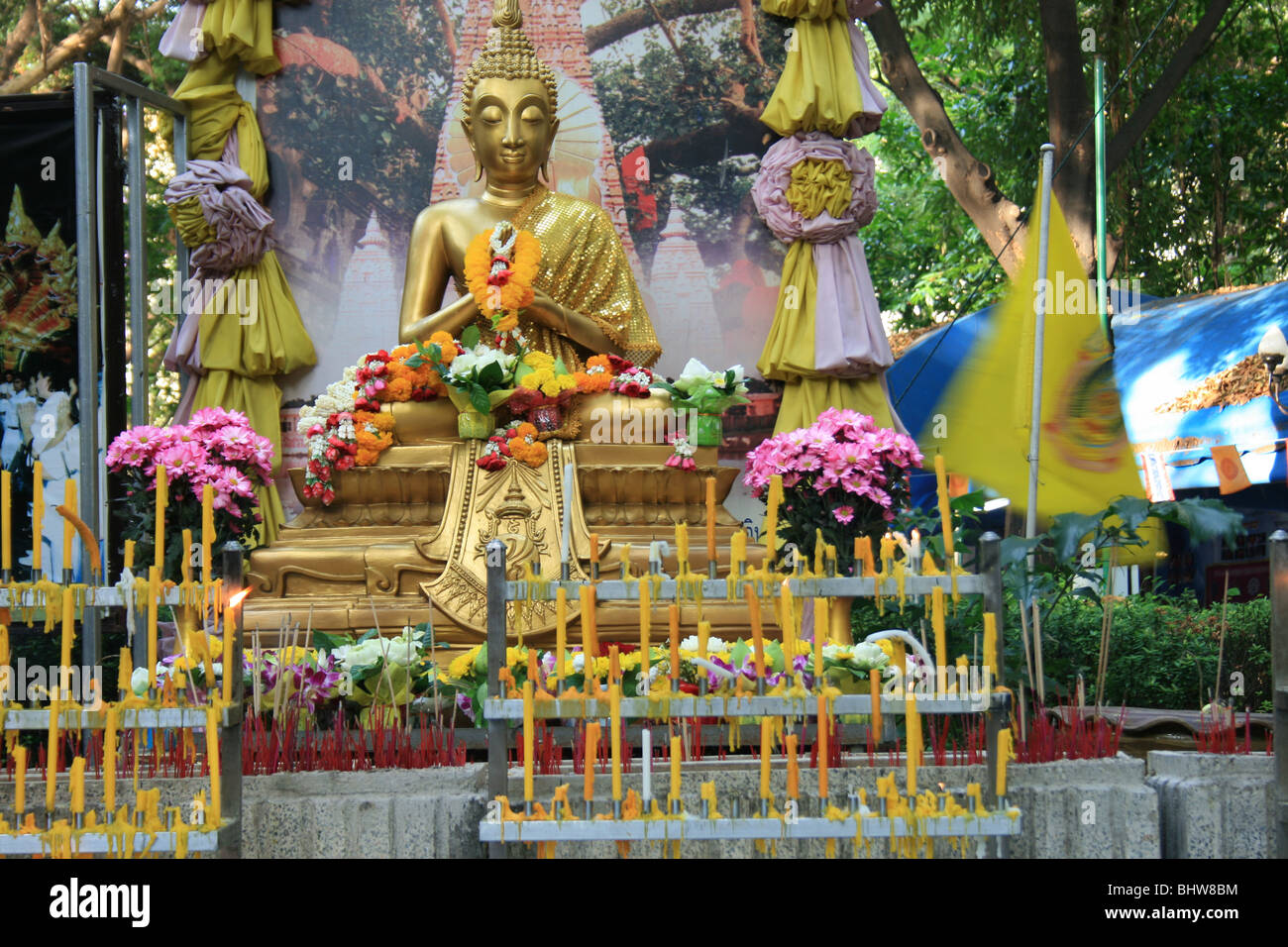 Gold Buddha statue shrine with candles, Bangkok, Thailand Stock Photo
