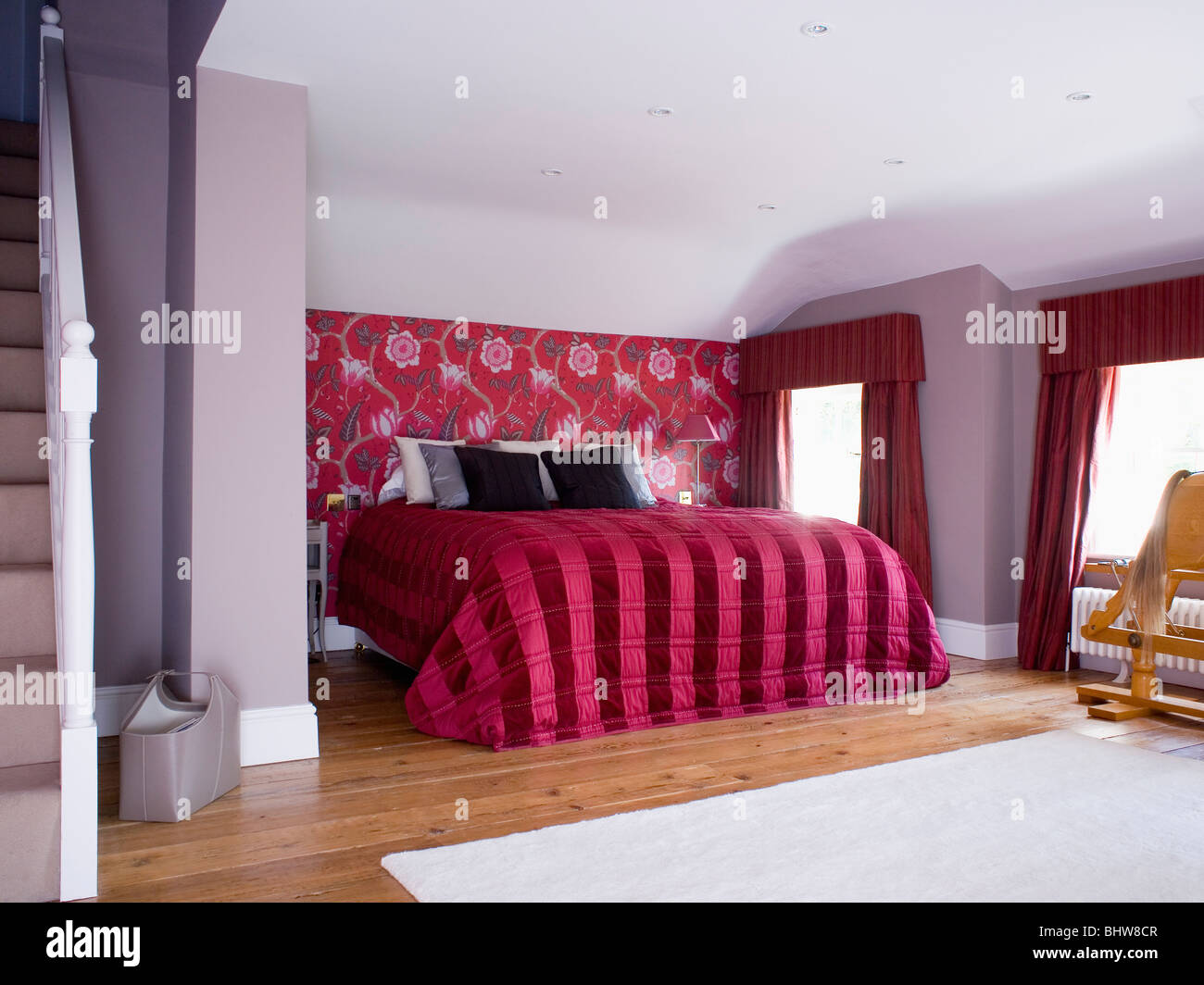 Red+black striped silk quilt on bed in mauve loft conversion bedroom with  red floral patterned wallpaper on wall behind bed Stock Photo - Alamy, image size:1300x1064