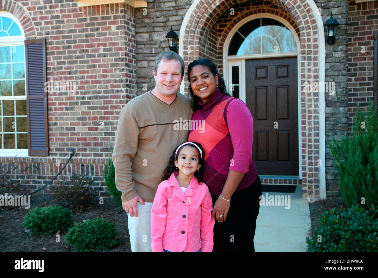 A family standing in front of their home Stock Photo - Alamy
