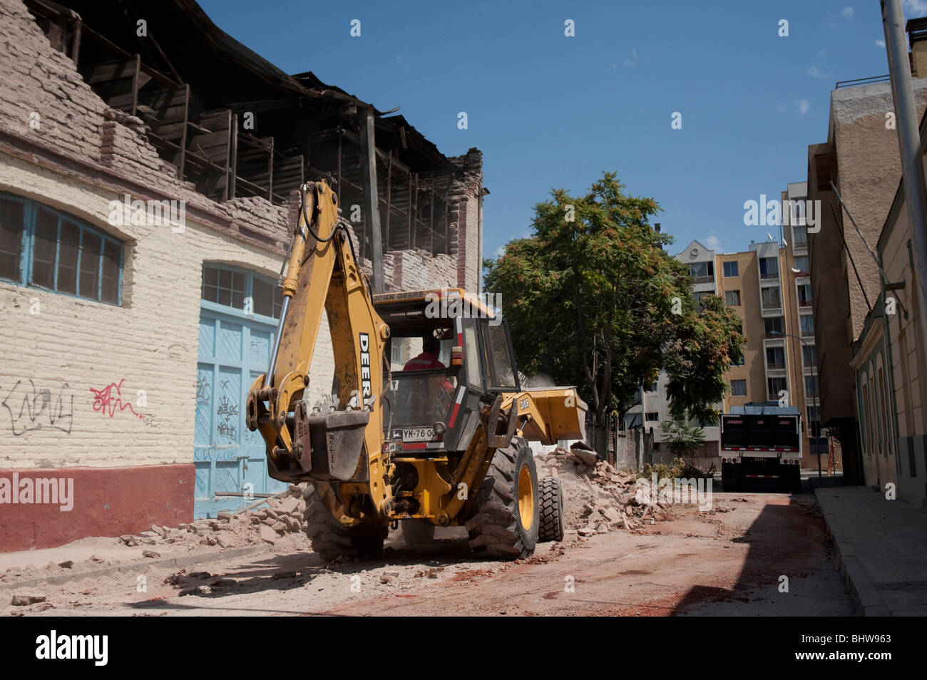 A Bucket Loader cleaning the debris of a collapsed wall Stock Photo - Alamy