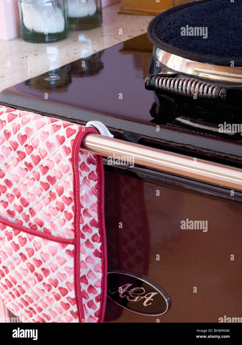 Close-up of red+white oven-mitt on black Aga oven Stock Photo