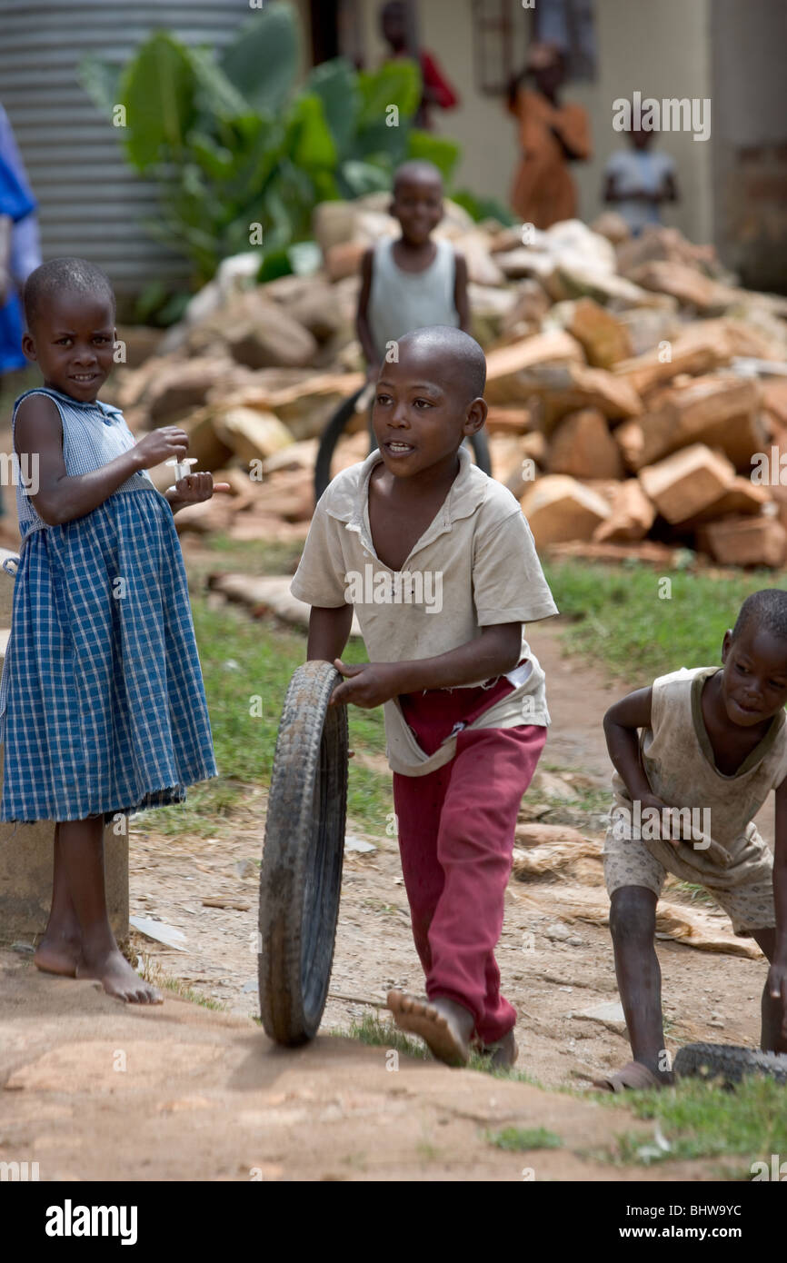 Boy playing with bicycle tyre in Uganda, Africa Stock Photo