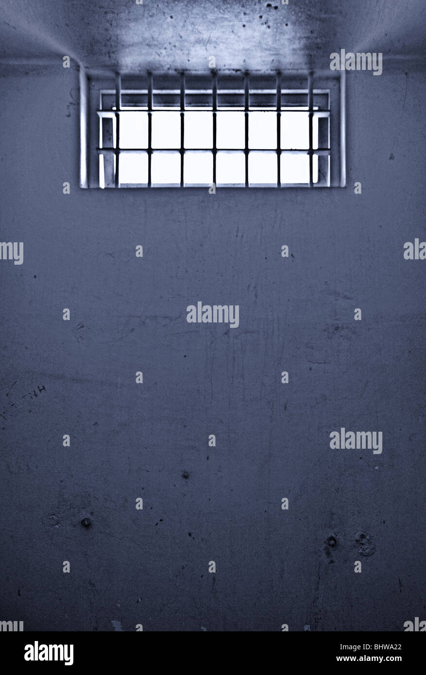 old dirty prison cell with barred window noise added for effect Stock Photo