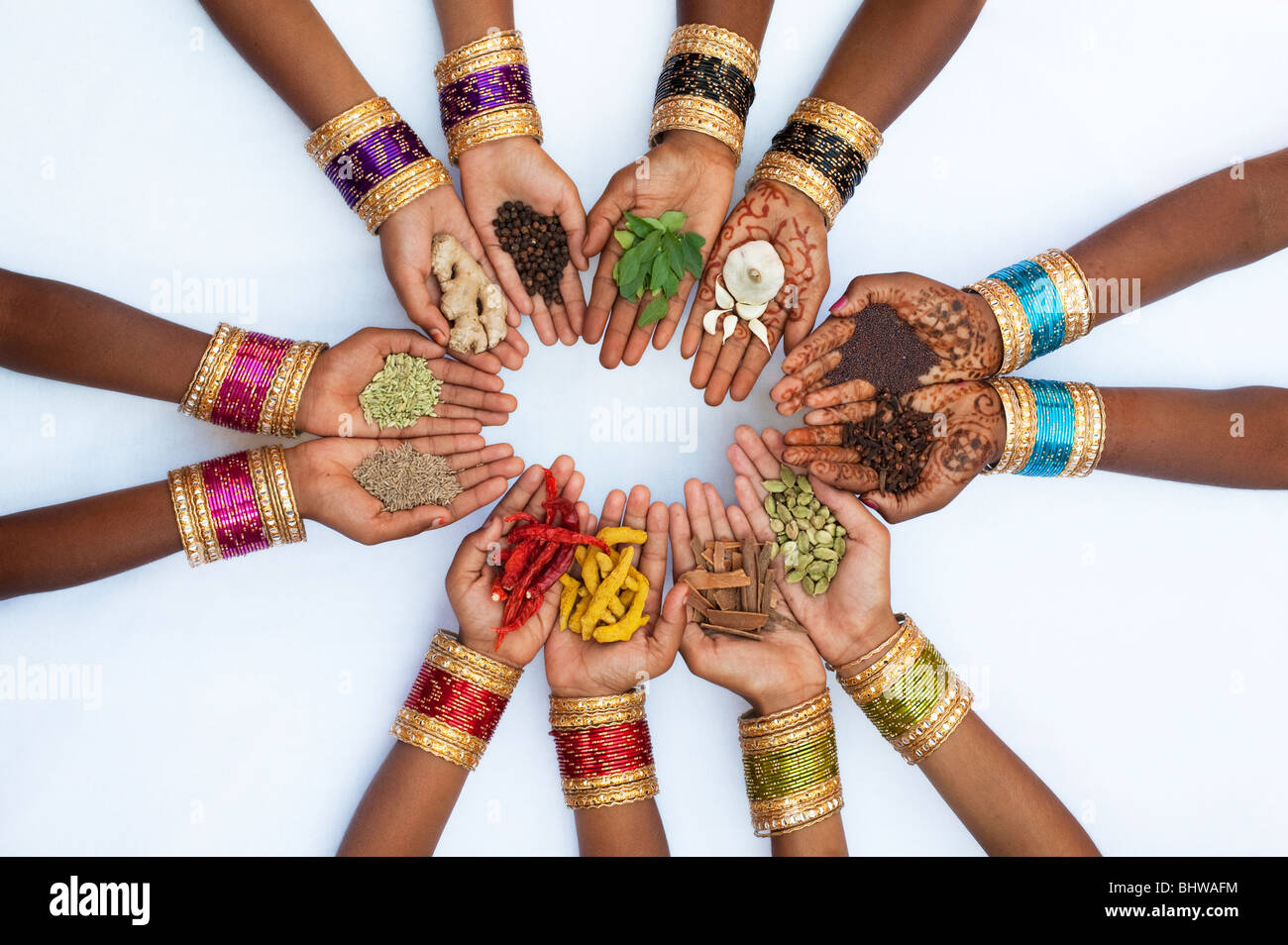 Indian children hands holding various indian cooking spices on white background Stock Photo