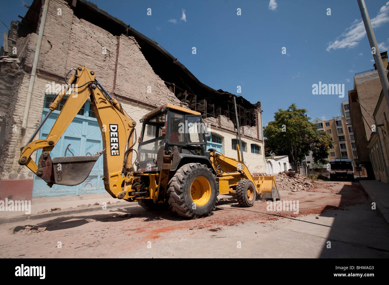 A Bucket Loader cleaning the debris of a collapsed wall Stock Photo - Alamy