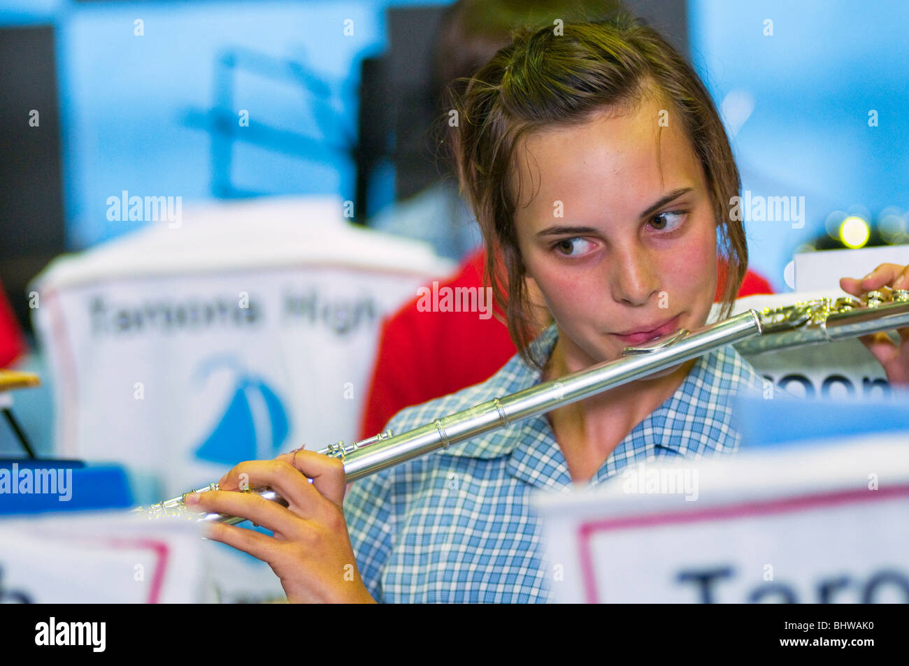 A young girl playing flute in a high school orchestra Stock Photo