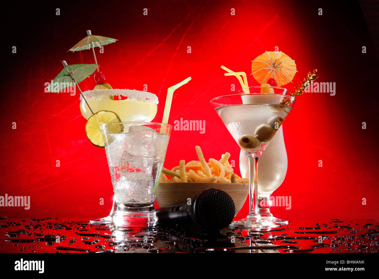 White drinks on red, Martini, Margarita, Fizz and Colada with chips and a karaoke mike Stock Photo