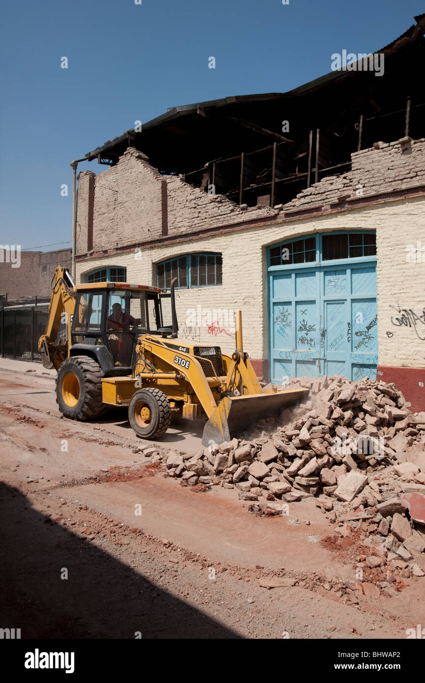 A Bucket Loader cleaning the debris of a collapsed wall Stock Photo - Alamy