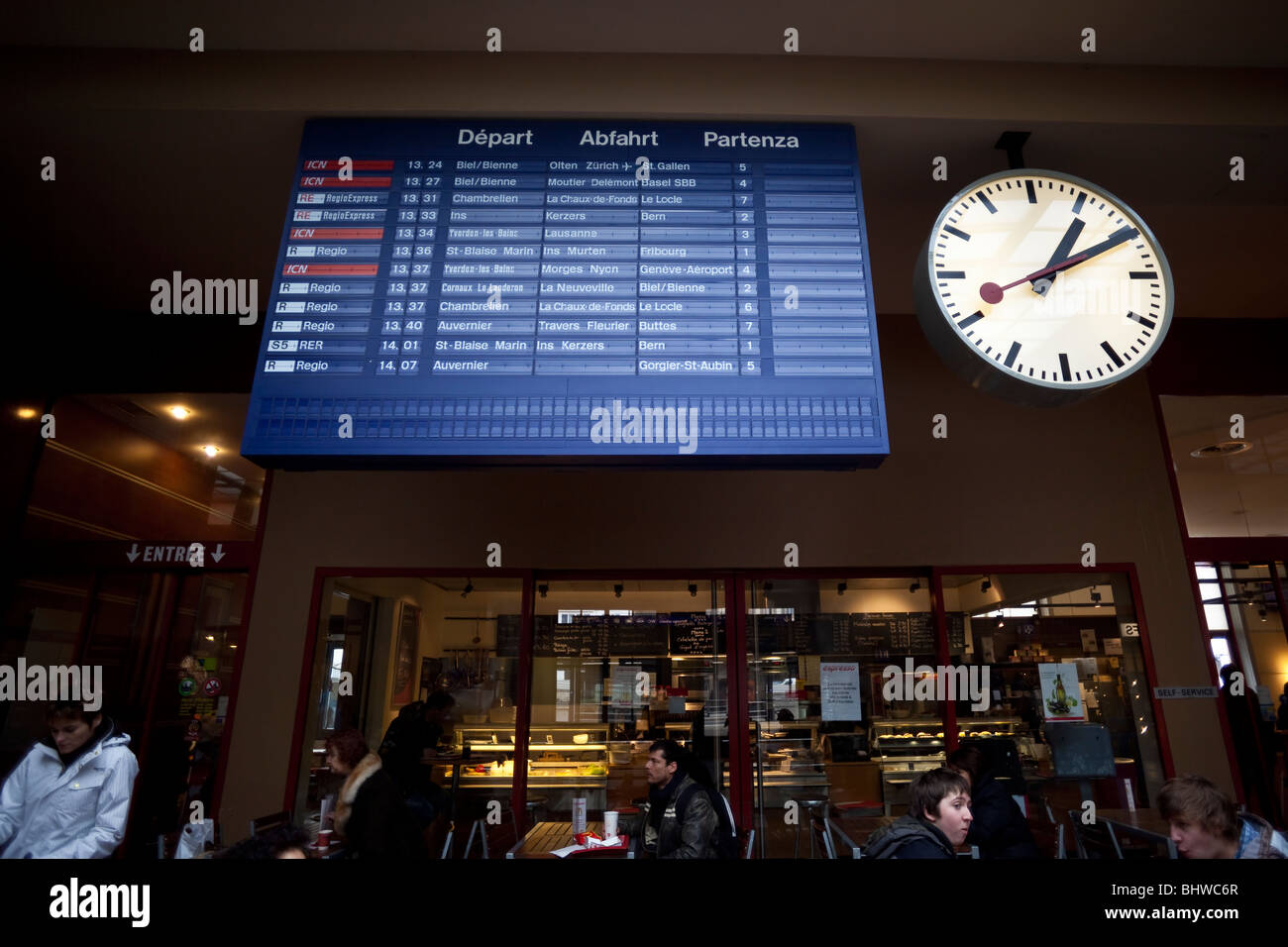 Clock and train schedule at the Neuchatel Switzerland train station by Charles Lupica. Stock Photo