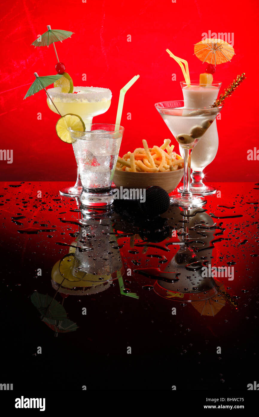 White drinks on red, Martini, Margarita, Fizz and Colada with chips and a karaoke mike Stock Photo