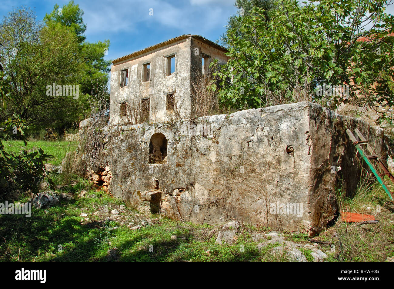 Vintage stone wine press tank and derelict house ruins. Zakynthos, Greece. Stock Photo