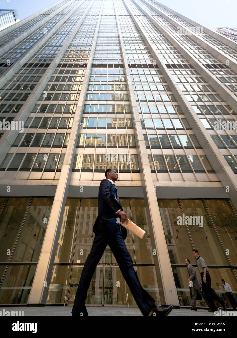 African American business man walking past One Manhattan Building, Wall Street, New York Stock Photo
