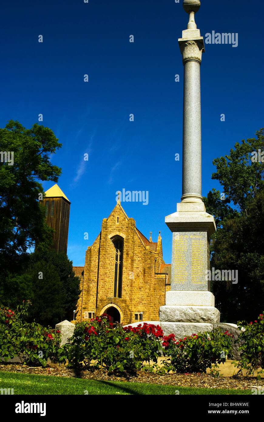 Flowers around the war memorial and Holy Trinity Anglican Cathedral Wangaratta under blue sky in North East Victoria Australia. Stock Photo