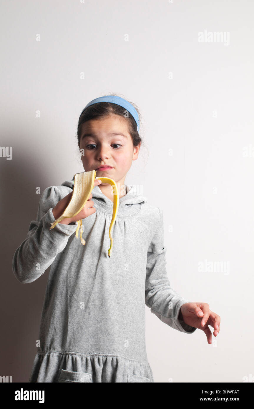 Child holding banana skin,pulling funny face Stock Photo