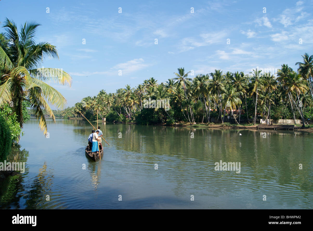 Kerala Coconut Palms landscape and Small Boat Journey of Village people through the backwaters.Scene from Kerala,India Stock Photo