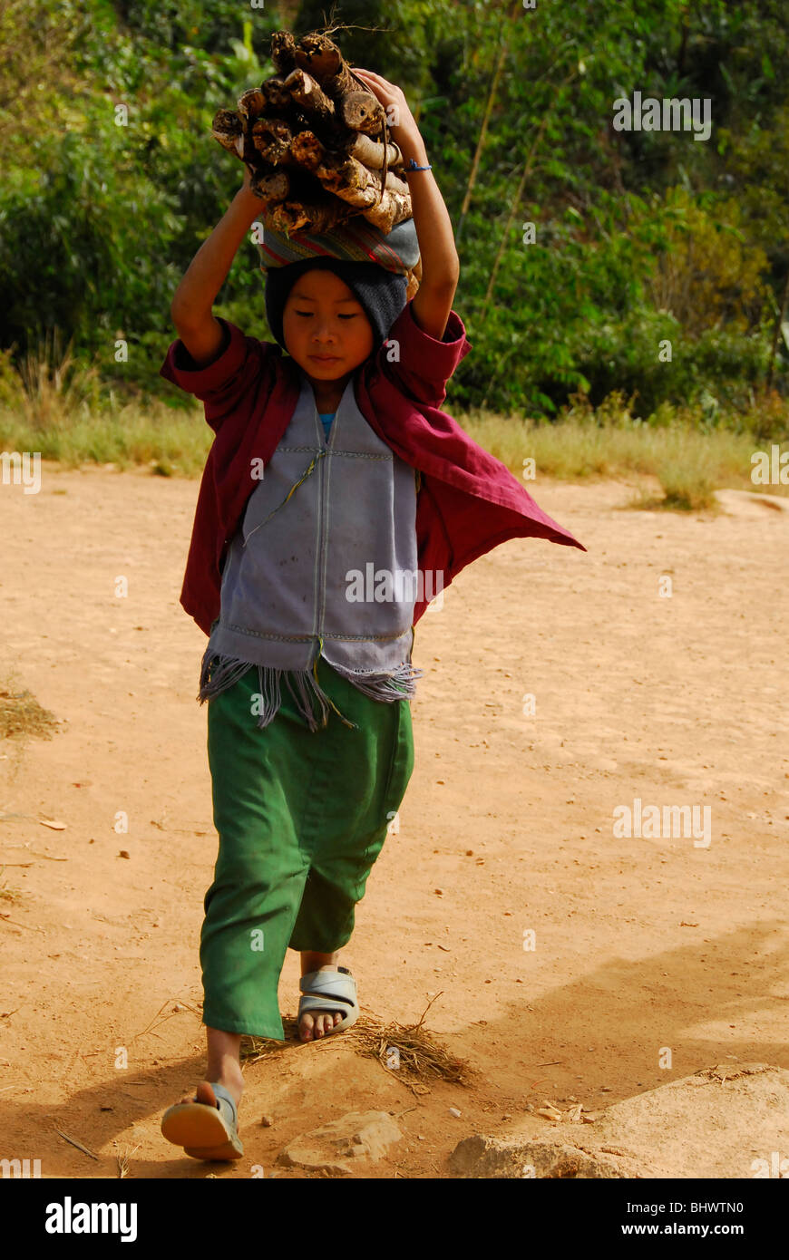 young karen girl carrying firewood , umpium refugee camp(thai burmese border) , south of mae sot , tak province , north thailand Stock Photo