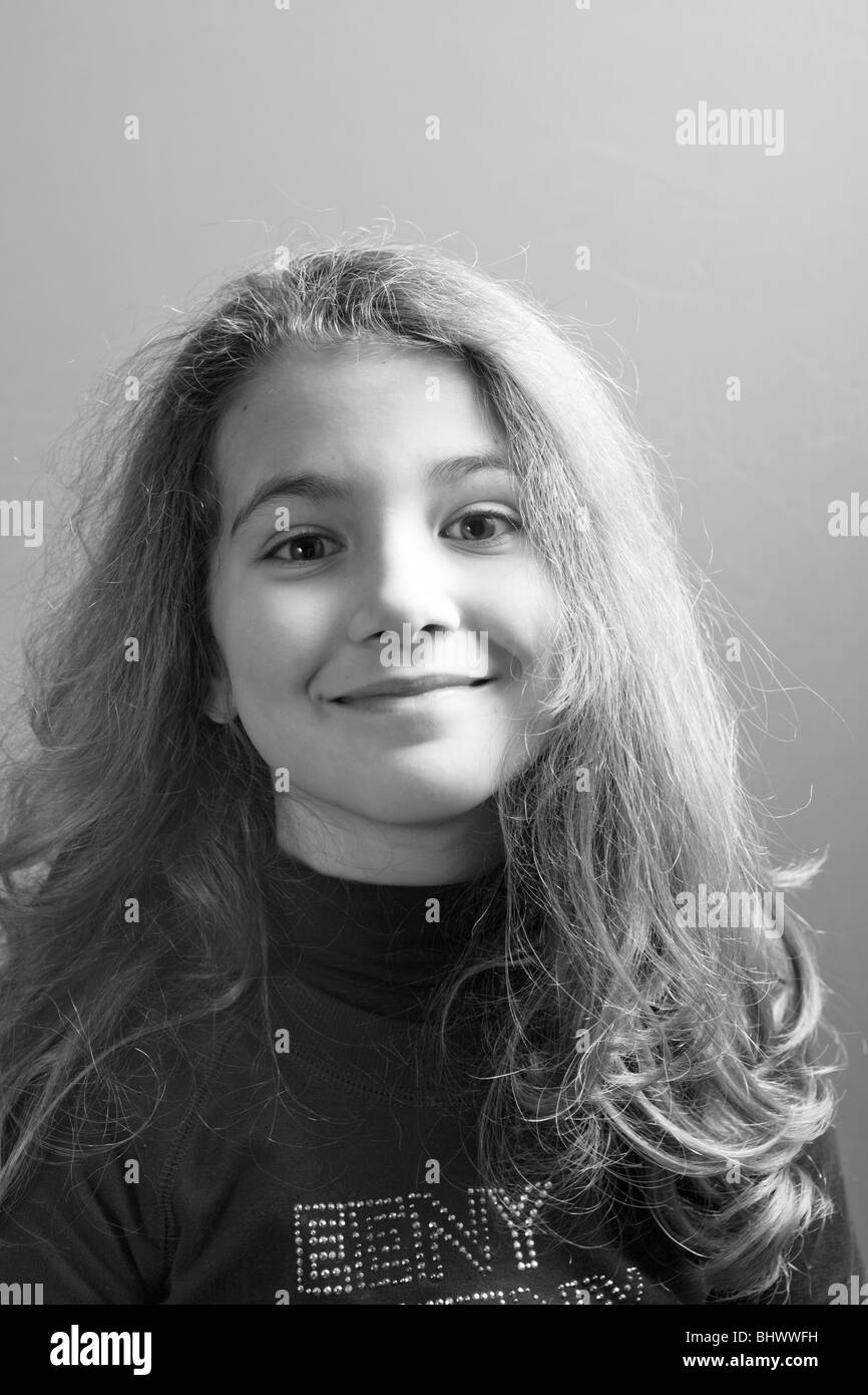 Black and white portrait of a young little girl smiling to the camera ...