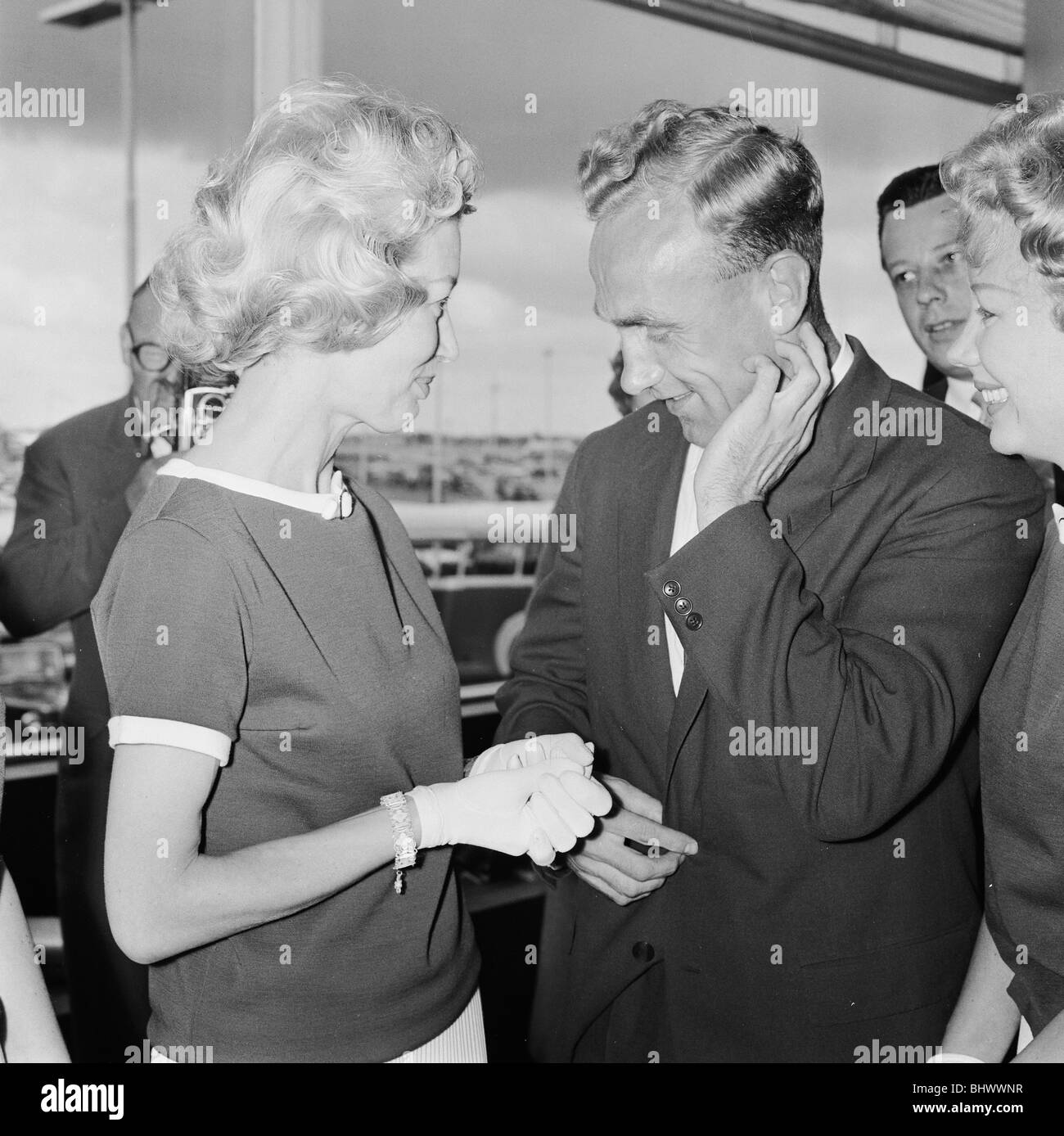 England footballer Billy Wright is greeted by his girlfriend Joy of the Beverley Sisters as he arrives at London Airport, following England's elimination from the 1958 World Cup tournament in Sweden. 23rd June 1958. Stock Photo