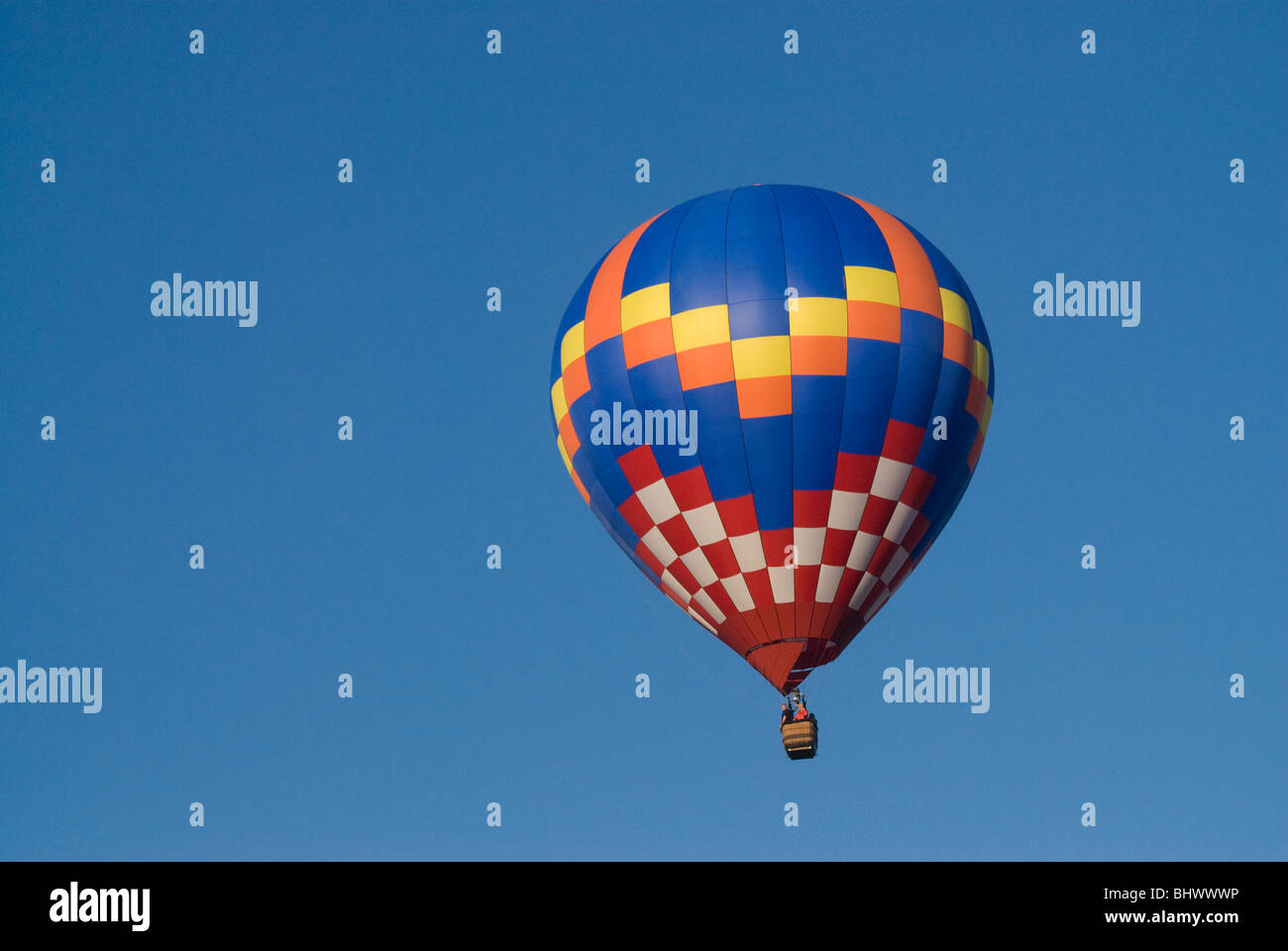 Colorful Hot air balloon flying up in a clear blue sky Stock Photo - Alamy