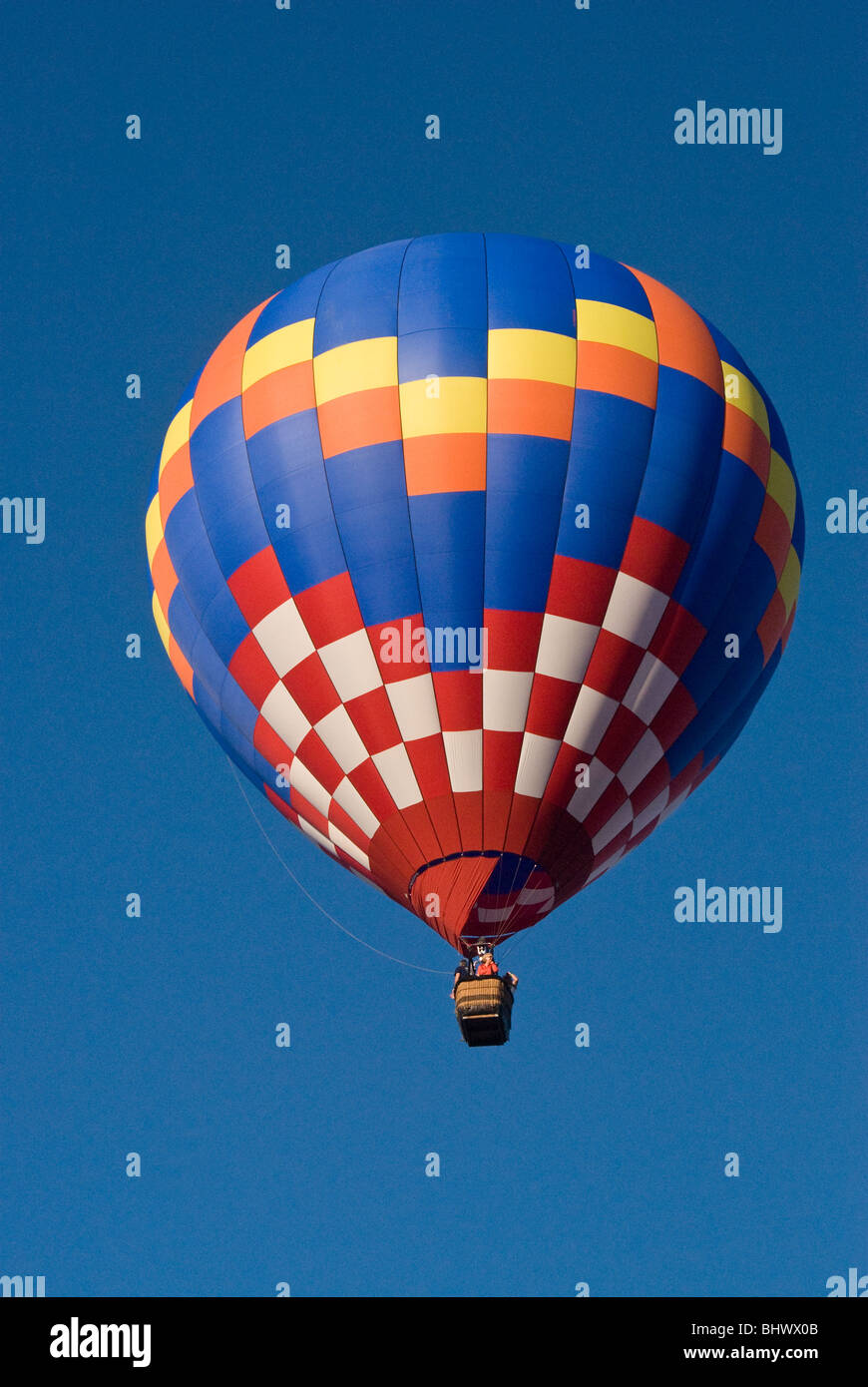 Colorful Hot air balloon flying up in a clear blue sky Stock Photo - Alamy