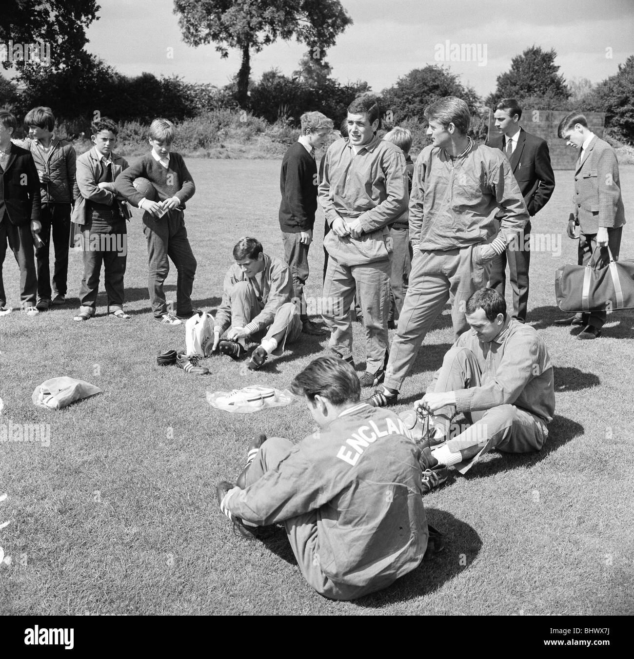 England team training during the World cup tournament in England. Children look on as players do up boot laces. 27th July 1966. Stock Photo