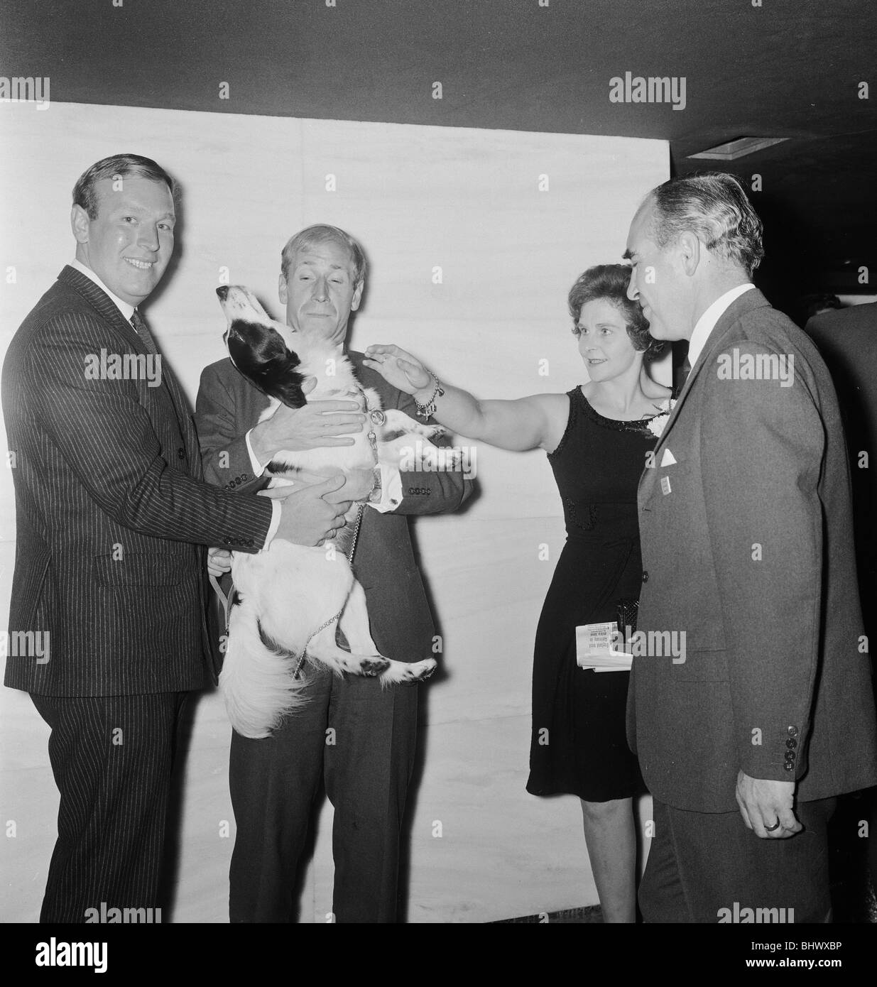 1966 World Cup Tournament in England. A World cup banquet was held for the victorious England team at the Royal Garden Hotel following thier victory over West Germany in the Final at Wembley. Bobby Charlton holds Pickles the hero dog who found the Jules Rimet after it had been stolen before the tournament, watched by manager Alf Ramsey. 31st July 1966. Stock Photo