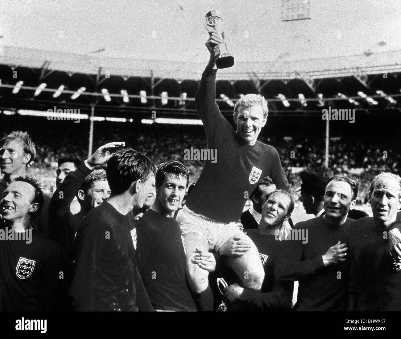 World Cup Final July 1966 at Wembley Stadium England 4 v West Germany 2 after extra time England captain Bobby Moore holds aloft the Jules Rimet trophy as he sits on the shoulders of his teammates after their World Cup win Stock Photo