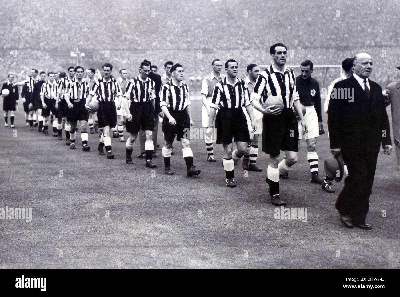 FA Cup Final 1952. Newcastle United vs Arsenal. 03/05/1952. The players walk out onto the famous Wembley pitch. The 1951/2 FA Cup run was one of the toughest imaginable. The Black ’n’ Whites met top sides Aston Villa, Tottenham, Portsmouth and Blackburn Rovers. And then they faced Arsenal at Wembley. Director-manager Stan Seymour leads out his team, followed by Bobby Cowell, Billy Foulkes, Jack Milburn, Bobby Mitchell (with the ball) and George Robledo. Stock Photo
