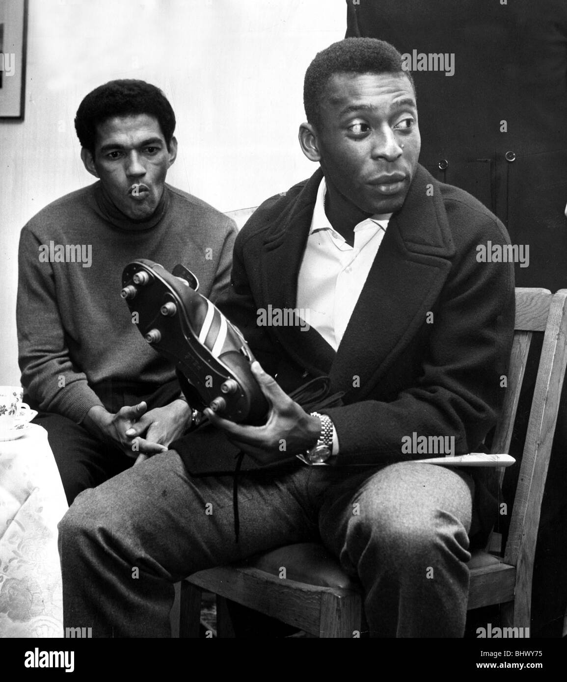 Brazilian football star Pele looking at a pair of football boots as team  mate Garrincha looks on. Brazil are in England for the Stock Photo - Alamy