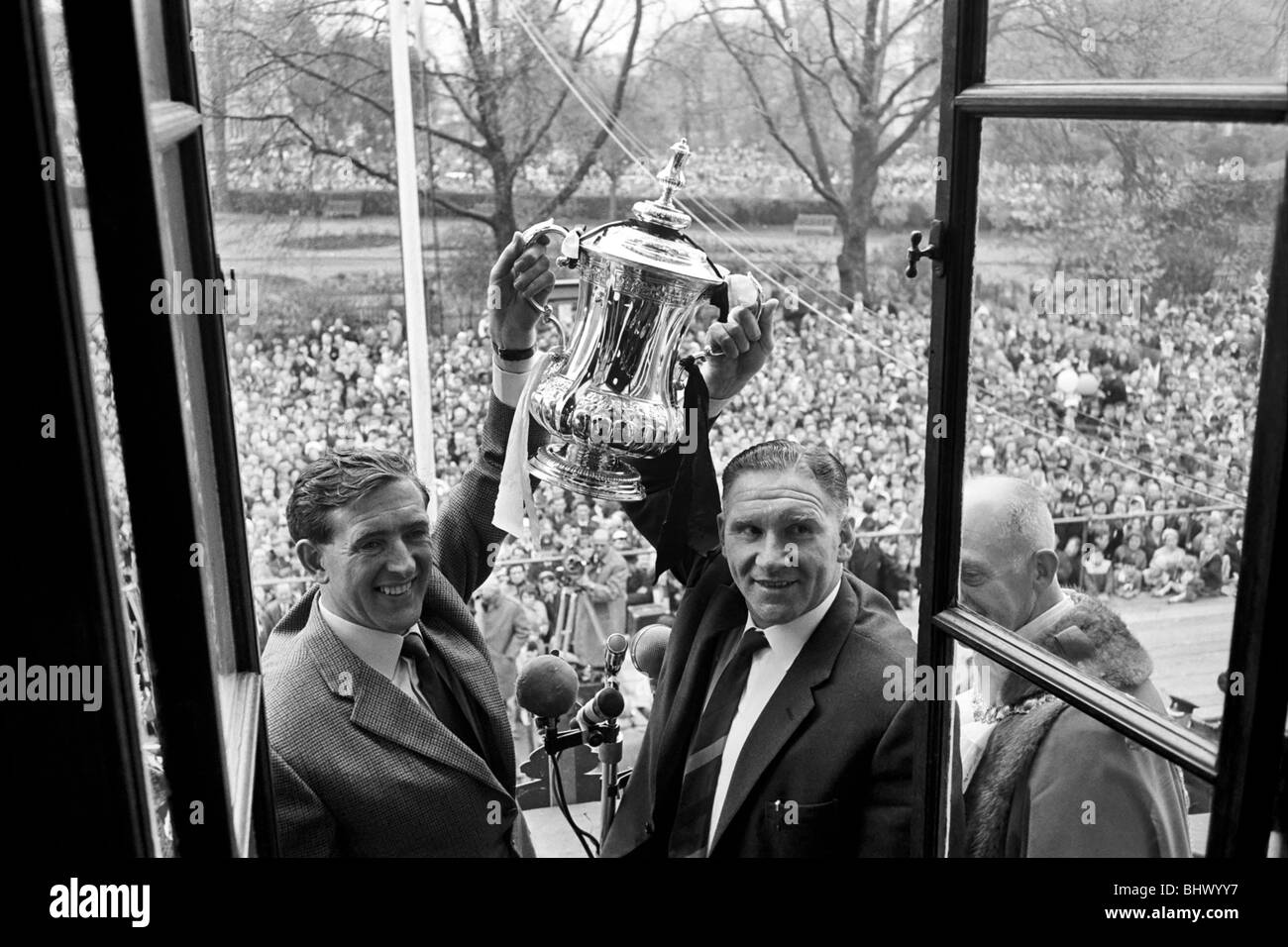 Tottenham Hotspur players parade the FA Cup trophy from the top of an open top double decker bus to thousands of fans gathered Stock Photo