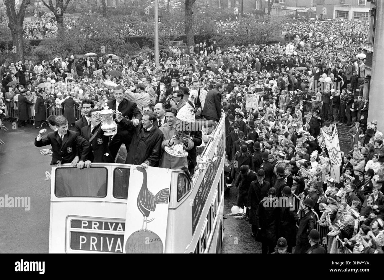 Tottenham Hotspur players parade the FA Cup trophy from the top of an open top double decker bus to thousands of fans gathered Stock Photo