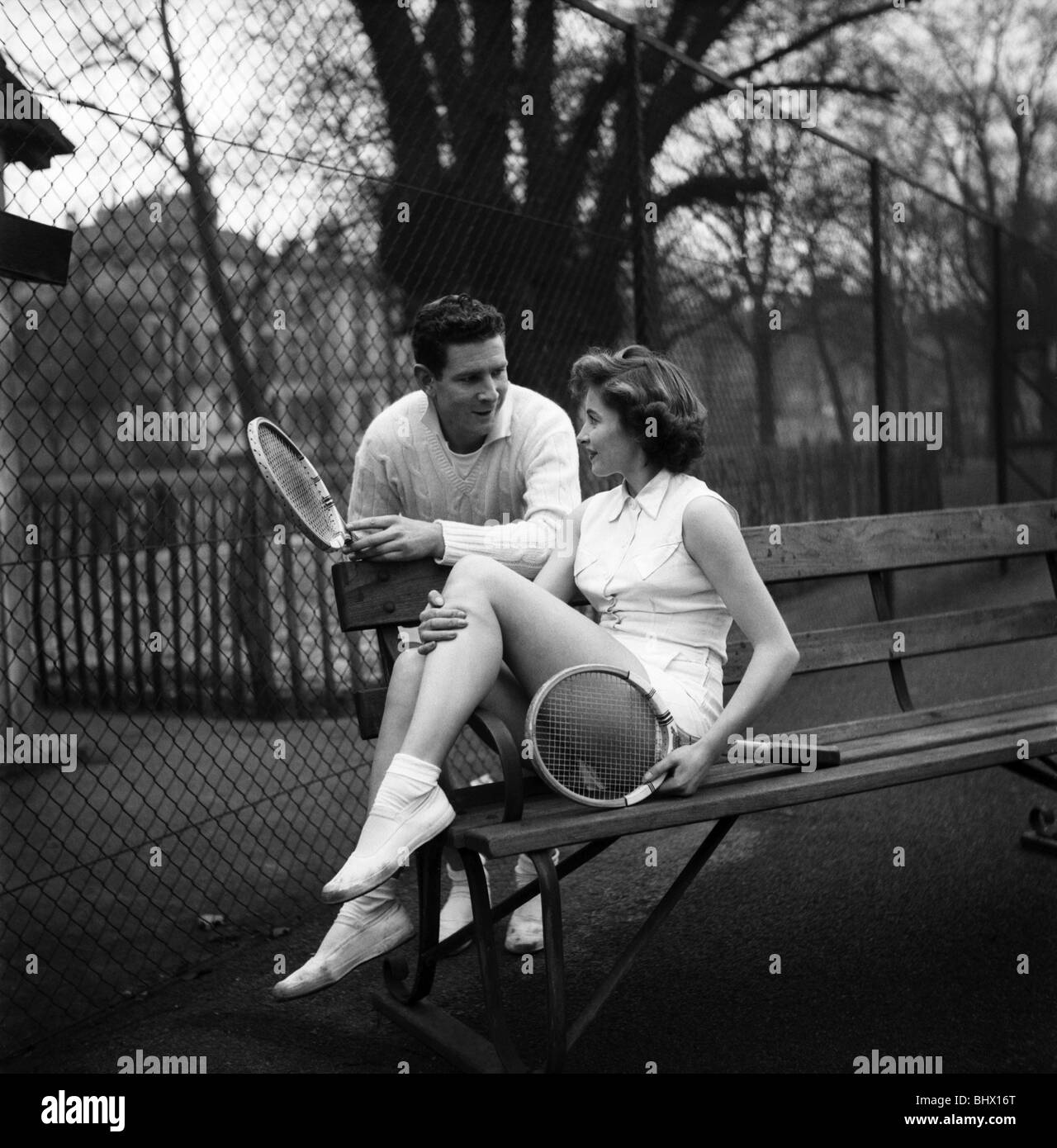 Man And Woman Talking On A Park Bench After Enjoying A Game Of