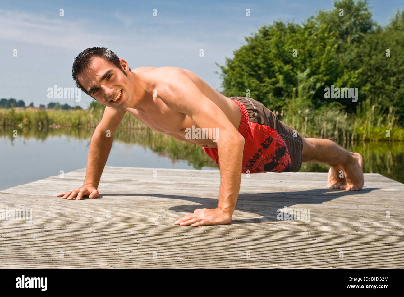 Young man doing push ups outside Stock Photo - Alamy