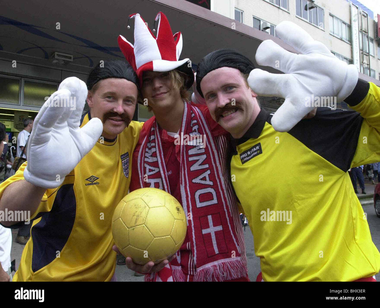 Football Fans Supporters June 2002 Pictured ahead of England v Denmark 2nd Round Match David Seamans Mel Kenny and Matt Wyatt 'save' a japanese denmark fan Stock Photo