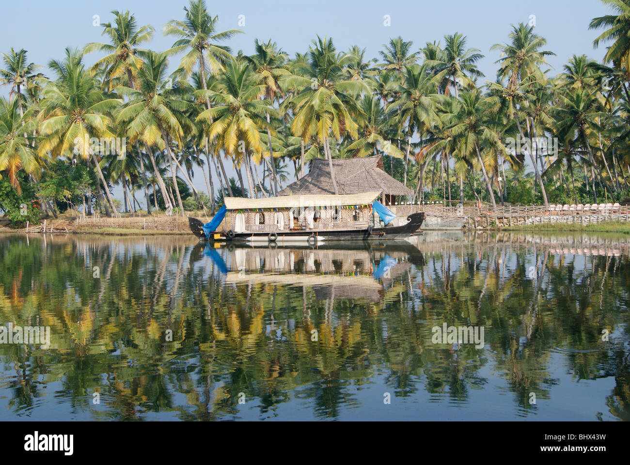 Honeymoon Special House Boat Resting near Beautiful kerala backwaters surrounded by greenish wide coconut palms at Kerala India Stock Photo