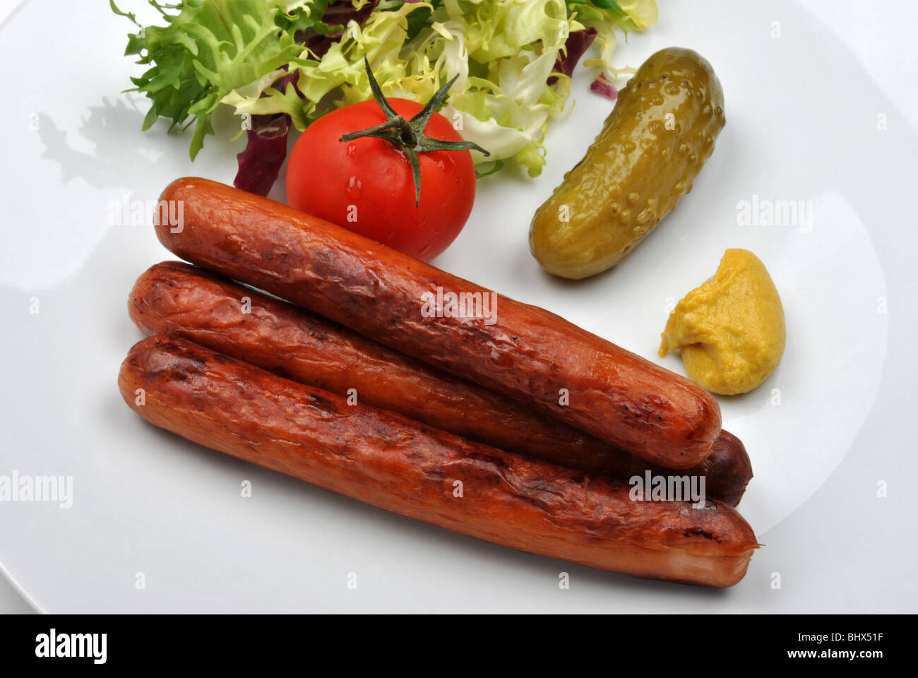 smoked sausage and organic gherkin on a plate Stock Photo