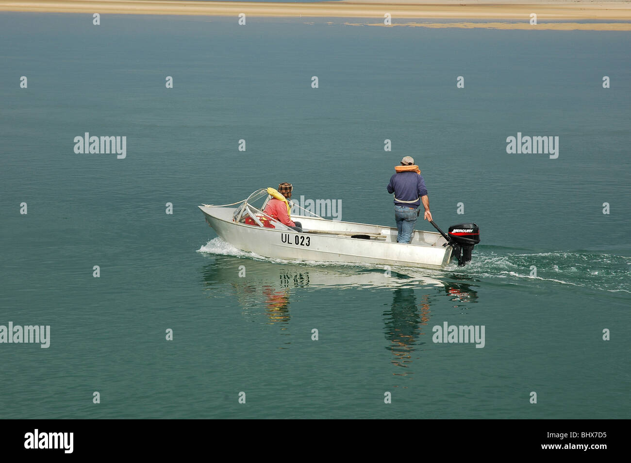 Two men in a boat leaving Inverloch inlet to go fishing, Autumn afternoon Stock Photo Alamy