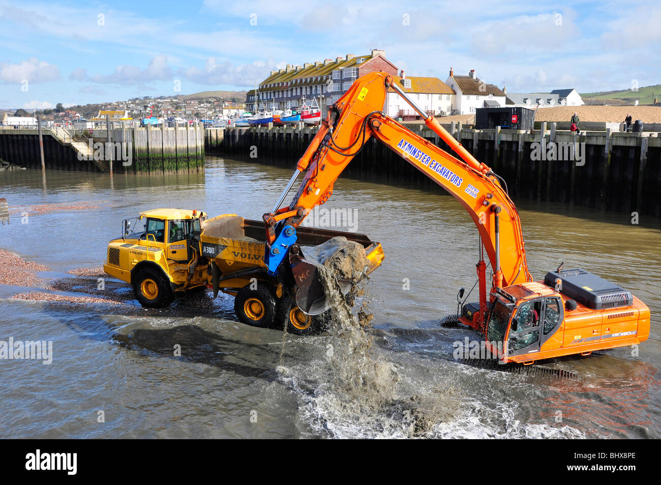 Dredging the harbour at West Bay in Dorset using tracked excavator