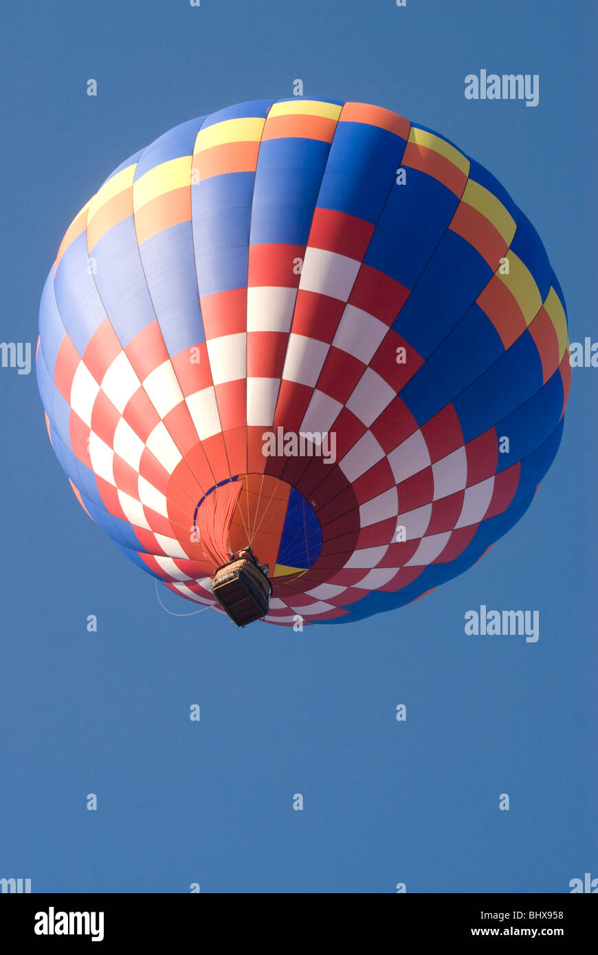 Colorful Hot air balloon flying up in a clear blue sky Stock Photo - Alamy